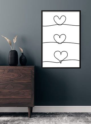 Minimalist poster with three connected heart outlines in a vertical line, displayed in a modern living room.