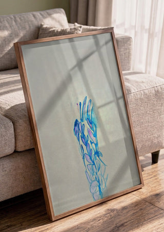Blue ChrysAlice by Alice Ruja in a walnut frame leaning against a grey sofa