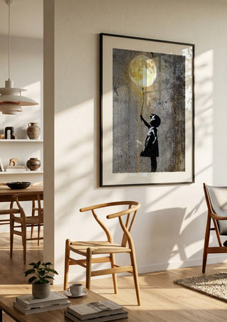 Moon Balloon by Decker Studios in a black frame in a bright dining room with wooden chairs