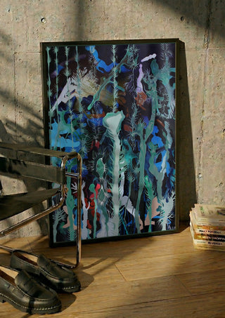 Mystical Garden by Andreas Pohle in a black frame leaning against a concrete wall by a steel chair