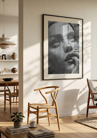 the dreamer by Sofia de Lemos in a black frame in a bright dining room with wooden chairs