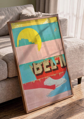 BEL-M by Kareem Rizk in a walnut frame leaning against a grey sofa