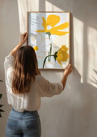 Yellow Flowers by ThingDesign being hung on a sunlit wall