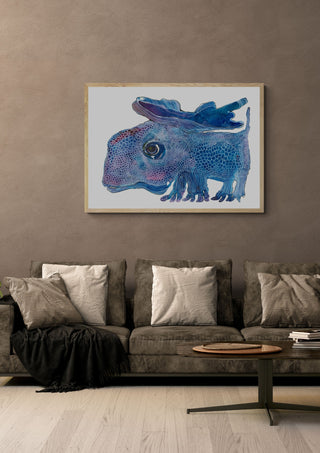 The Blue Watcher by Lena Galé in a light oak frame above a grey sofa on a warm brown wall