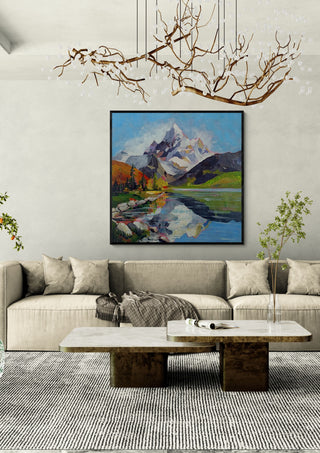 Still Waters, Endless Peaks by Evgenia Smirnova in a black frame above a cream sofa under a branch chandelier