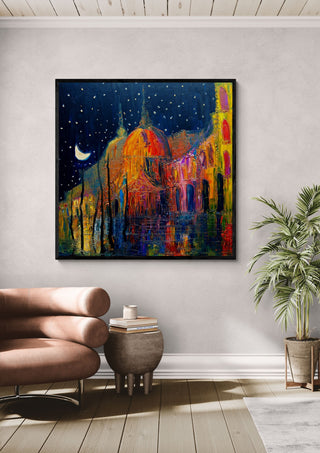 Crescent over the Domes by Justyna Kopania in a black frame above a leather armchair beside a palm