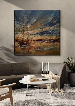 Masts in Golden Light by Justyna Kopania in a black frame above a dark sofa with candlesticks on a round table