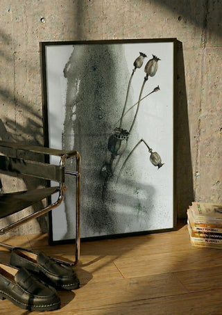 Death by Tania Zubareva in a black frame leaning against a concrete wall by a steel chair