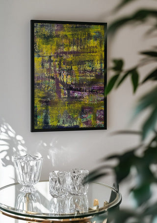 Sonnenschein by Sophie Schillen in a black frame above a glass table with crystal glassware