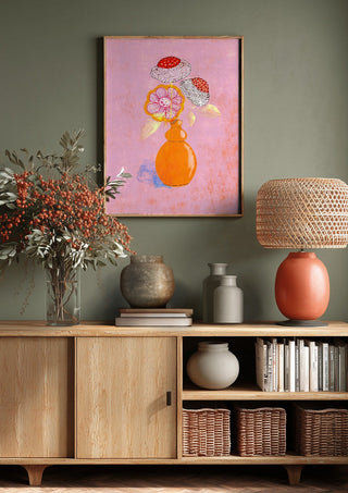 Flowers in an Orange Vase by Creationsbyeditabrus above a wooden sideboard on a sage green wall