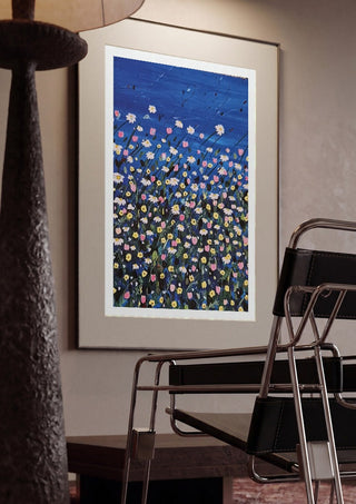 Daisies by Rebecca Wright framed in a dim room beside a tubular steel chair