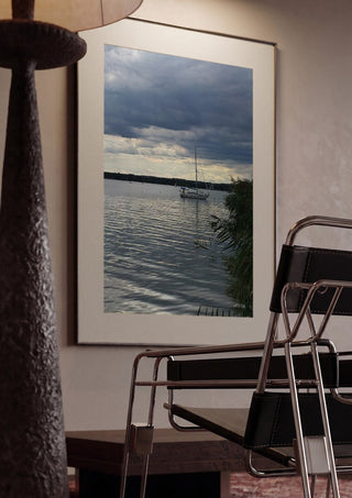 Light Reaching the Water by Bora Kőhalmi framed in a dim room beside a tubular steel chair