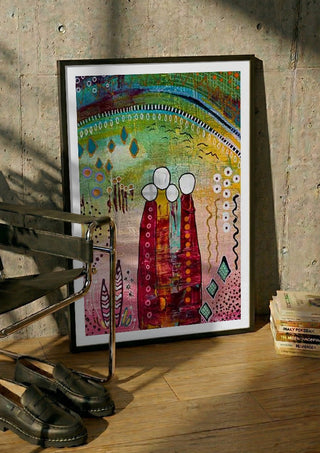 Fairy Tale 1 by Art Anne Lee in a black frame leaning against a concrete wall by a steel chair