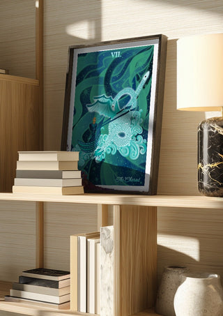 The Chariot by Sciurus tarotus in a dark frame on a wooden shelf beside books and a lamp