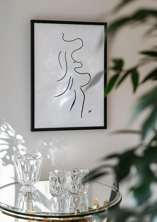 I am move by FridaRit in a black frame above a glass table with crystal glassware
