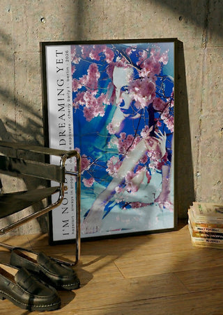 cherry baily by hazelart in a black frame leaning against a concrete wall by a steel chair