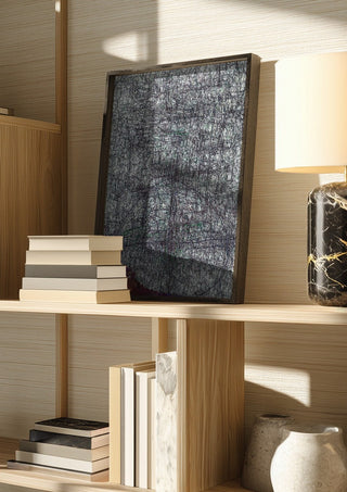 Targeted by Priit Ruttas in a dark frame on a wooden shelf beside books and a lamp