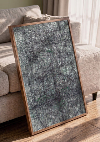 Targeted by Priit Ruttas in a walnut frame leaning against a grey sofa