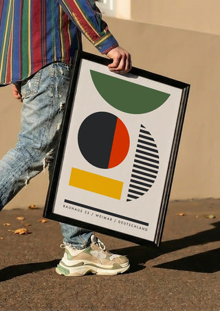 Bauhaus Shapes by Neil Stevens carried in a black frame along a sunny street