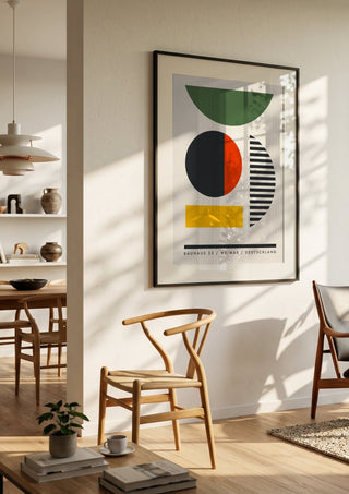 Bauhaus Shapes by Neil Stevens in a black frame in a bright dining room with wooden chairs