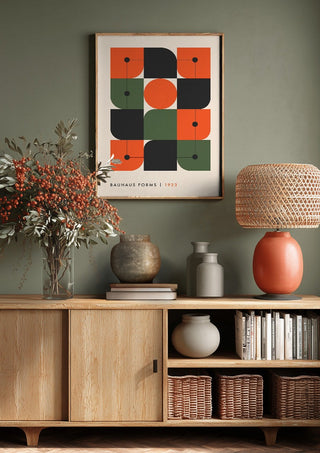 Bauhaus Forms 1923 by Neil Stevens above a wooden sideboard on a sage green wall
