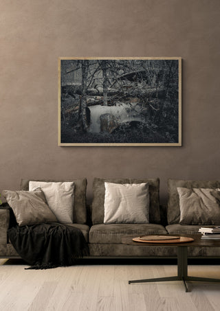 Decay (1) by Lone Gjessing in a light oak frame on a warm grey wall above a brown sofa