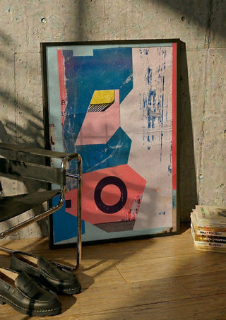 Abstract Composition No.2 by Kareem Rizk in a black frame leaning against a concrete wall by a steel chair