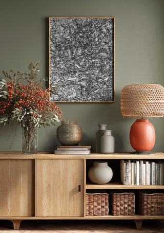 Resized Imagination by Priit Ruttas above a wooden sideboard on a sage green wall