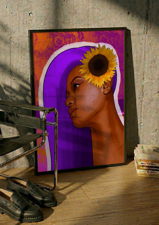 Golden Focus by Sabrina Rosenblatt in a black frame leaning against a concrete wall by a steel chair
