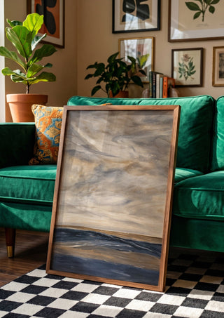 Whispers of Silence by Maya in a wooden frame leaning against a green velvet sofa on a chequered floor
