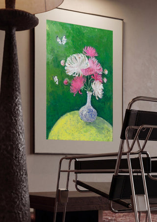 Chrysanthemums by Deblina Dey framed in a dim room beside a tubular steel chair