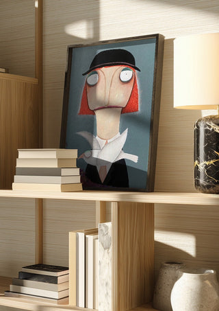 Malwines Strickmöwe by lacaluna in a dark frame on a wooden shelf beside books and a lamp