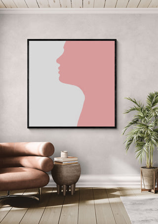 Pure by Tonia in a black frame above a pink armchair beside a palm