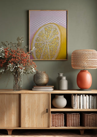 Half Lemon by L.OE. Art above a wooden sideboard on a sage green wall