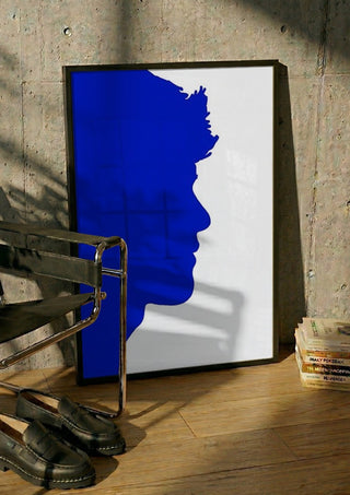 Projected personality by Tonia in a black frame leaning against a concrete wall by a steel chair