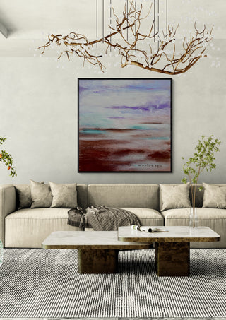 Lavender Haze by Marina Agre in a black frame above a beige sofa under a branch chandelier