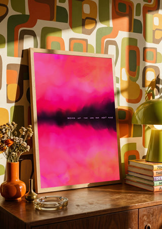 Never let them know your next move by Astrid Lind in a wooden frame on a sideboard against retro patterned wallpaper