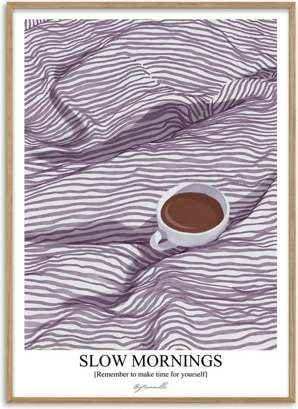 A cup of coffee on a striped bedspread, with "Slow Mornings" and ByKammille branding below.