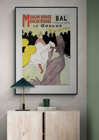 Framed Pour Le Moulin Rouge - Lautrec poster featuring vibrant cabaret scene, displayed above a modern cabinet.